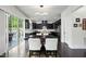 Bright kitchen with black cabinets, stainless steel appliances, granite counters, and a breakfast nook with backyard access at 7517 Summer Pines Way, Wake Forest, NC 27587