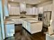Bright modern kitchen featuring white cabinets, granite countertops, stainless steel appliances, and hardwood floors at 7517 Summer Pines Way, Wake Forest, NC 27587