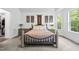 The spacious main bedroom features neutral carpet, a metal bed frame and several windows with backyard views at 7517 Summer Pines Way, Wake Forest, NC 27587