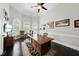 Well-lit home office with a large desk, dark hardwood floors, paneled windows, and tasteful decor at 7517 Summer Pines Way, Wake Forest, NC 27587