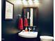 Nicely decorated powder room featuring a corner sink with a dark painted walls at 775 Sid Eaves Rd, Youngsville, NC 27596