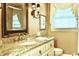 Elegant bathroom with granite countertop, decorative lighting, and a framed mirror at 775 Sid Eaves Rd, Youngsville, NC 27596