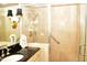 Elegant bathroom featuring walk-in shower with glass doors, and vanity with dark countertop at 775 Sid Eaves Rd, Youngsville, NC 27596