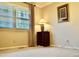 Sunny bedroom featuring hardwood floors, large window with blinds, and a classic side table at 775 Sid Eaves Rd, Youngsville, NC 27596