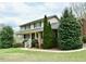 Well-manicured lawn highlights this two-story home, adorned with lush green trees and a welcoming front porch at 775 Sid Eaves Rd, Youngsville, NC 27596