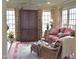 Cozy sunroom featuring large windows, a comfortable sofa, wicker chair, and floral-patterned curtains at 775 Sid Eaves Rd, Youngsville, NC 27596