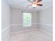Bedroom with neutral walls, plush carpet, ceiling fan, and window letting in natural light at 8124 Greywinds Dr, Raleigh, NC 27615