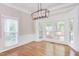 Elegant dining area with hardwood flooring, large bay window, and stylish light fixture at 8124 Greywinds Dr, Raleigh, NC 27615