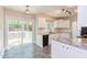 Bright kitchen features white cabinets, granite countertops, and stainless-steel appliances, with a sliding door to an outdoor deck at 8124 Greywinds Dr, Raleigh, NC 27615