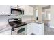 Close up of a renovated kitchen with stainless-steel appliances, granite countertops, and white cabinets at 8124 Greywinds Dr, Raleigh, NC 27615