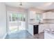 Bright kitchen features white cabinets, granite countertops, and stainless-steel appliances, with a sliding door to an outdoor deck at 8124 Greywinds Dr, Raleigh, NC 27615