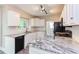 Well-lit kitchen featuring granite countertops, black appliances, and white cabinetry at 8124 Greywinds Dr, Raleigh, NC 27615