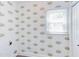 Small room with fun floral-themed wallpaper, a window with blinds, and an electrical outlet at 8124 Greywinds Dr, Raleigh, NC 27615