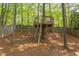 Wooden backyard treehouse with ladder, surrounded by trees at 8124 Greywinds Dr, Raleigh, NC 27615