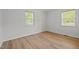 Bedroom with natural light features new hardwood floors, neutral paint, and two large windows at 84 Honeysuckle Dr, Pittsboro, NC 27312