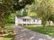 Charming home with a long driveway, mature trees and lush green lawn at 84 Honeysuckle Dr, Pittsboro, NC 27312