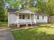 Charming one story home with white siding, covered front porch, and green lawn at 84 Honeysuckle Dr, Pittsboro, NC 27312