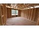 A view of an unfinished bedroom space, with exposed framing and a bright window overlooking the outdoors at 91 Gobbler Dr, Smithfield, NC 27577
