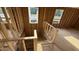 Unfinished wooden staircase ascending to the next level with natural light streaming through the windows at 91 Gobbler Dr, Smithfield, NC 27577