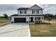 Two-story home featuring a black garage door and a covered front porch at 10 Silver Ct, Smithfield, NC 27577