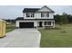 New two-story home with a black door, black shutters, black garage, and a well-manicured lawn at 10 Silver Ct, Smithfield, NC 27577