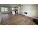 Open-concept living room with wood flooring, a shiplap fireplace accent wall, and an adjacent kitchen at 10 Silver Ct, Smithfield, NC 27577