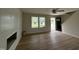 Open-concept living room with modern wood-look floors, a fireplace feature wall, and view to front door at 10 Silver Ct, Smithfield, NC 27577