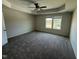 Spacious main bedroom featuring neutral carpeting, tray ceilings, a ceiling fan, and a bright window view at 10 Silver Ct, Smithfield, NC 27577