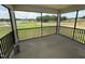 A screened porch with a scenic view of the grassy lawn and pond at 10 Silver Ct, Smithfield, NC 27577