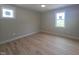 Bright bedroom featuring hardwood floors, two windows, and neutral paint at 1005 Forrestal Pl, Durham, NC 27707
