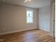 Bright bedroom with hardwood floors, neutral paint, and a large window offering natural light at 1005 Forrestal Pl, Durham, NC 27707