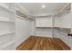 Walk-in closet featuring custom shelving, wooden rods, and hardwood flooring at 1005 Forrestal Pl, Durham, NC 27707