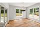 Sunlit dining room with hardwood floors and large windows overlooking the outdoors at 1005 Forrestal Pl, Durham, NC 27707