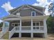 Two-story home featuring a covered front porch with white columns and railings, complemented by gray siding and a gabled roofline at 1005 Forrestal Pl, Durham, NC 27707