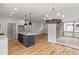 Open kitchen and dining area with hardwood floors, island, and sliding door access at 1005 Forrestal Pl, Durham, NC 27707