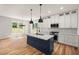 Bright kitchen features a central island, quartz countertops, and stainless steel appliances at 1005 Forrestal Pl, Durham, NC 27707