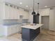 Bright kitchen featuring a center island, modern light fixtures, and shaker cabinets with sleek hardware at 1005 Forrestal Pl, Durham, NC 27707
