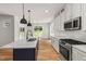 Modern kitchen boasts a center island with seating, stainless steel appliances, and natural light at 1005 Forrestal Pl, Durham, NC 27707