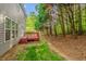 View of the backyard with a red wooden deck and a grassy area at 101 Hay Sedge Ct, Durham, NC 27705