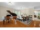 Elegant dining room featuring a grand piano, hardwood floors, and a large dining table at 101 Hay Sedge Ct, Durham, NC 27705