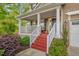 Inviting front porch with red steps, white railings, and a view of the landscaped garden at 101 Hay Sedge Ct, Durham, NC 27705