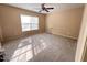 Carpeted bedroom features neutral walls, ceiling fan, and a large window providing natural light at 102 Revere Forest Ct, Cary, NC 27519