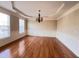 Formal dining room with hardwood floors, chandelier, wainscoting, and large windows at 102 Revere Forest Ct, Cary, NC 27519