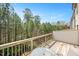 Balcony overlooking tall pine trees and lush greenery with table and chairs set for relaxing at 103 Ballyliffen Ln, Cary, NC 27519