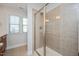 Tiled shower with glass door in a bathroom with a window offering natural light at 103 Ballyliffen Ln, Cary, NC 27519