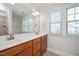 Bright bathroom featuring a double sink vanity, large mirror, and natural light from the window at 103 Ballyliffen Ln, Cary, NC 27519