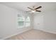 Comfortable carpeted bedroom features a ceiling fan, closet, and a window with a view at 103 Ballyliffen Ln, Cary, NC 27519