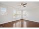 Bright bedroom features hardwood floors, three windows, a ceiling fan, and white walls at 103 Ballyliffen Ln, Cary, NC 27519