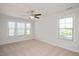 Carpeted bedroom featuring a ceiling fan and windows overlooking the outdoor views at 103 Ballyliffen Ln, Cary, NC 27519