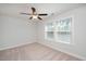 Bright, carpeted bedroom features a ceiling fan and a window overlooking an outdoor view at 103 Ballyliffen Ln, Cary, NC 27519